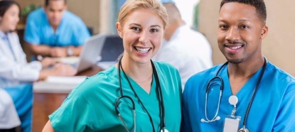 Millennial nurse pic. Female and male nurses standing next to each other.